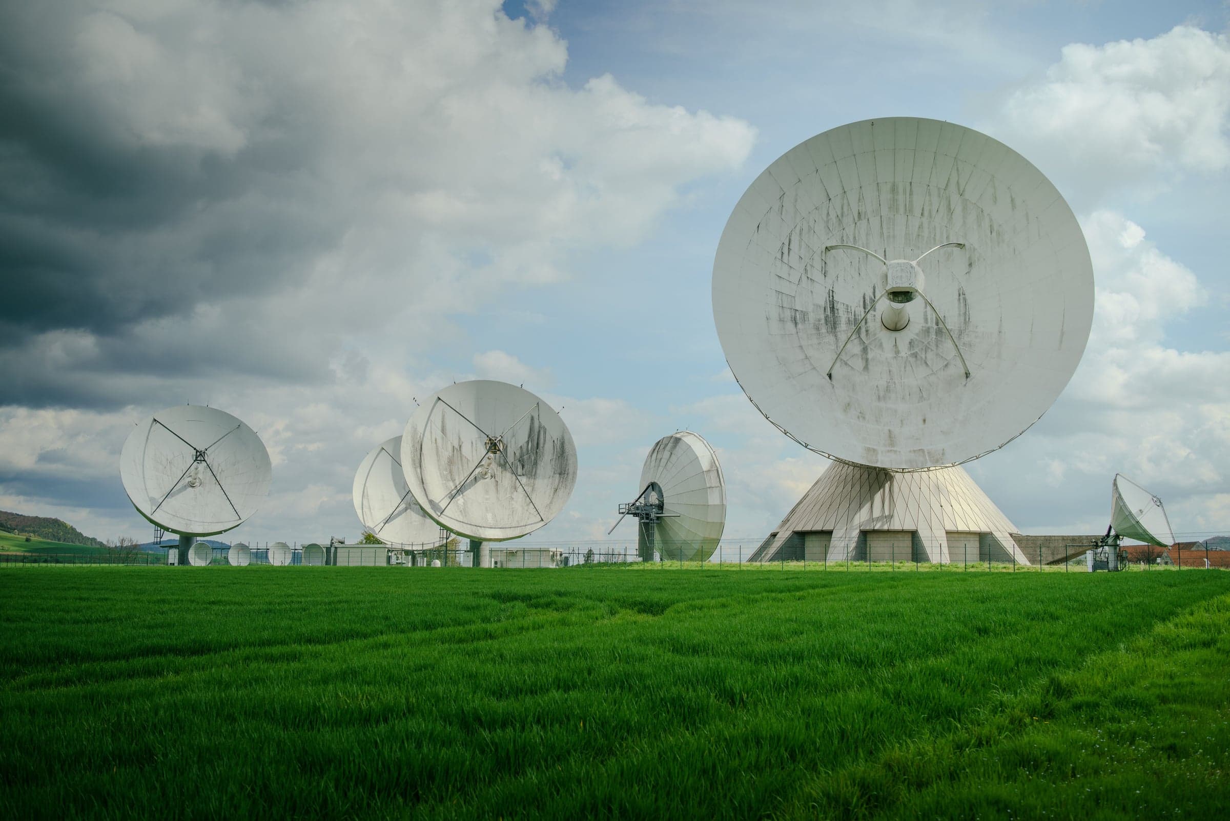 Parabolic antennas of a satellite communications ground station in a meadow