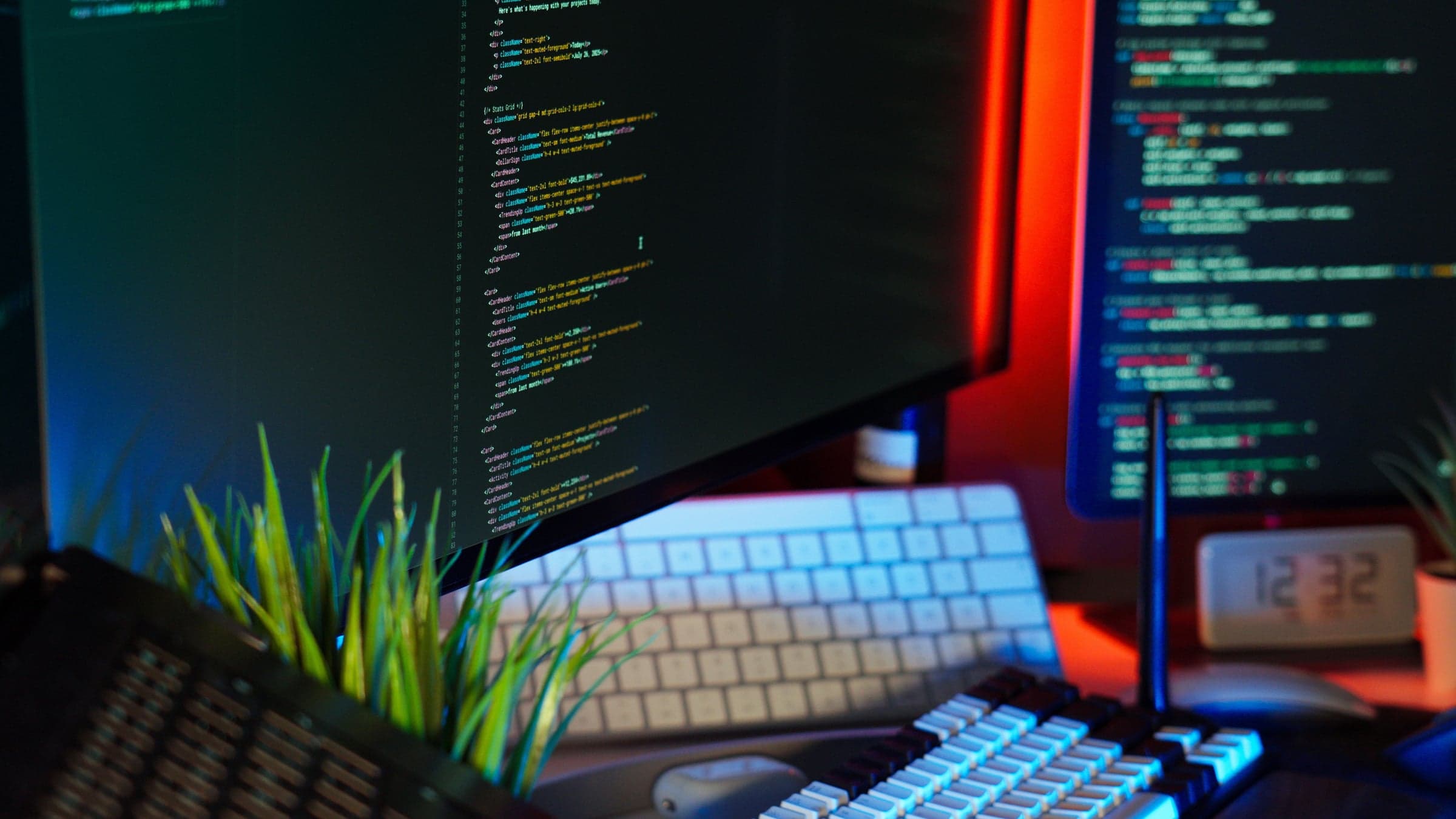 Developer workstation at night, code as a soft glow on two monitors